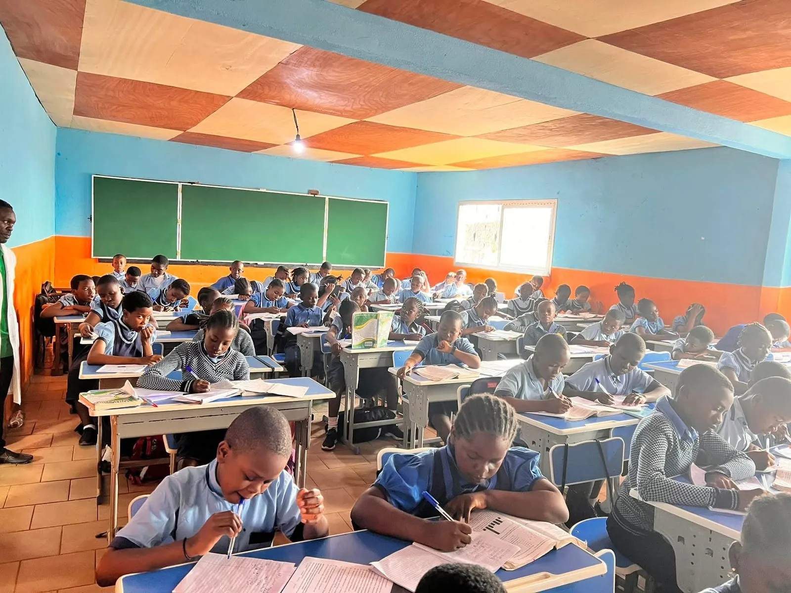 Secondary school students studying attentively in their classroom at BGS — modern blue desks, engaged pupils