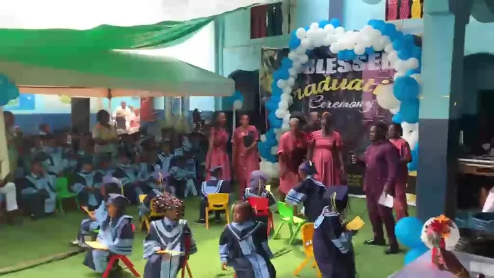 BASNPS graduation ceremony — pupils in gowns with blue and white balloons
